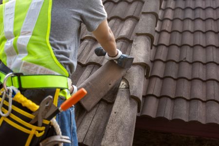Roof Workers Fixing And Replacing Roof Tiles